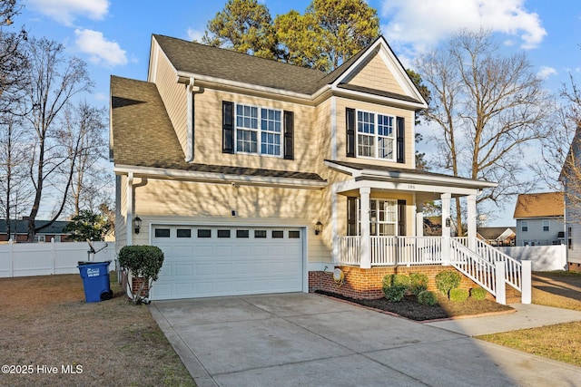 traditional home featuring a porch, a shingled roof, an attached garage, fence, and driveway