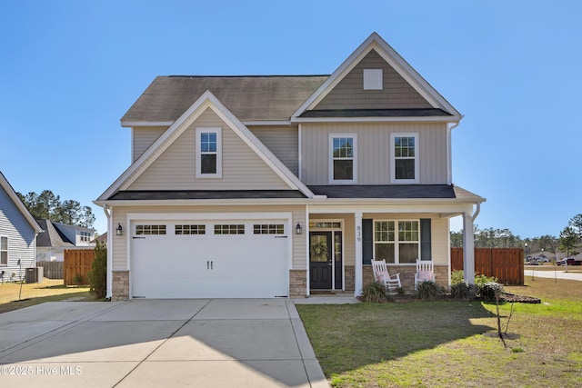 craftsman house featuring a front lawn, fence, covered porch, concrete driveway, and a garage