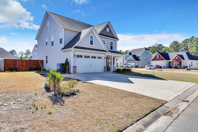 view of side of property featuring driveway, fence, a yard, a residential view, and an attached garage