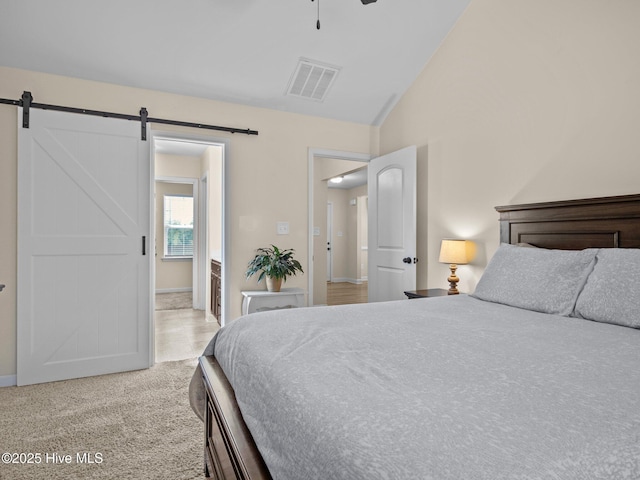 bedroom featuring light colored carpet, visible vents, a barn door, ceiling fan, and vaulted ceiling