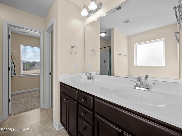 bathroom with double vanity, a sink, and visible vents