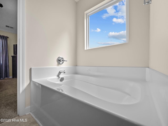 full bathroom with a garden tub, tile patterned flooring, and visible vents