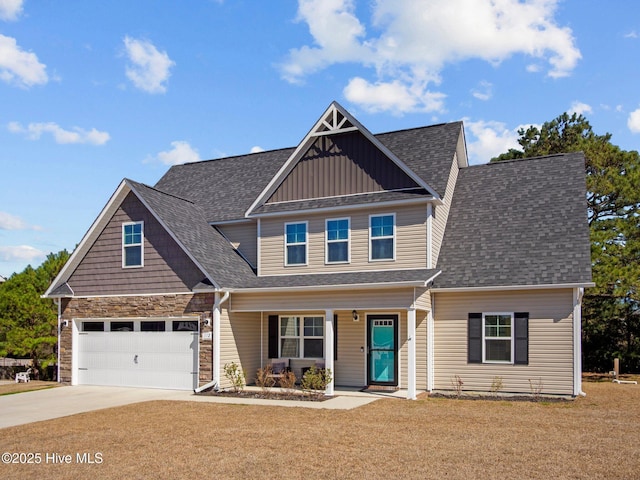 view of front of property featuring driveway, stone siding, a shingled roof, and a front yard