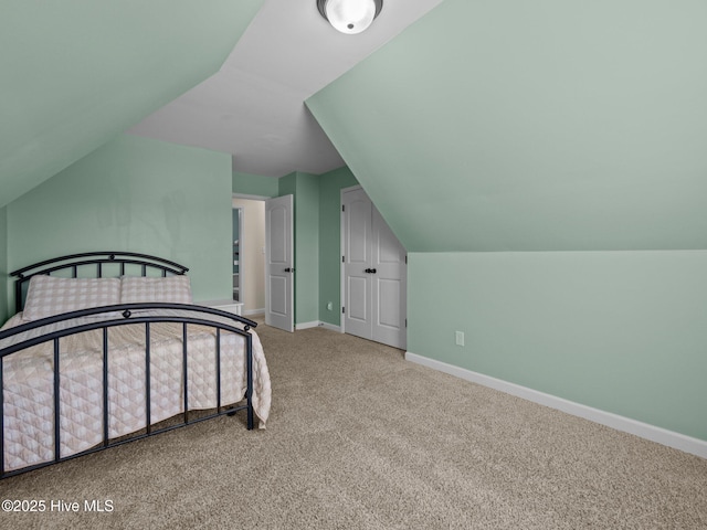 bedroom with carpet floors, lofted ceiling, and baseboards