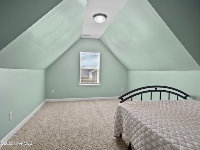 carpeted bedroom with visible vents, vaulted ceiling, and baseboards