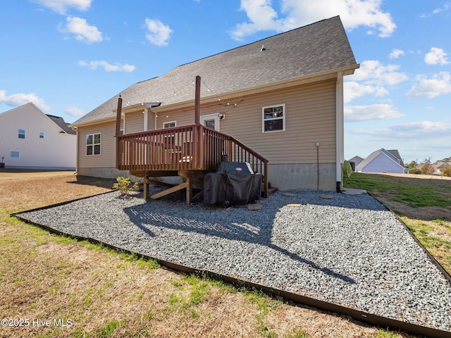 back of property with roof with shingles and a deck