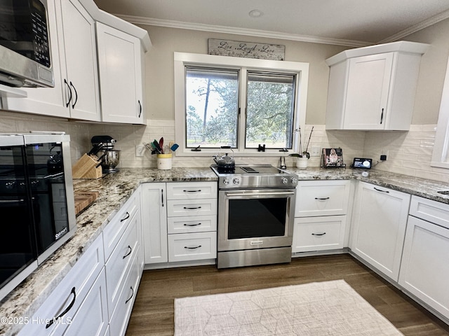 kitchen with appliances with stainless steel finishes, white cabinets, and crown molding