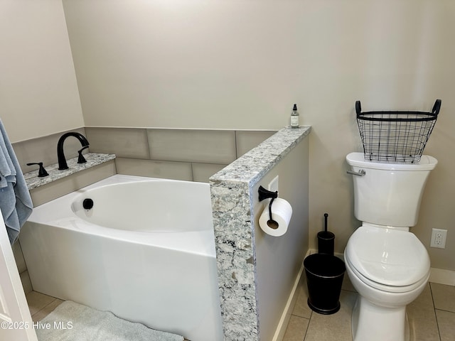 bathroom featuring a bath, baseboards, toilet, and tile patterned floors