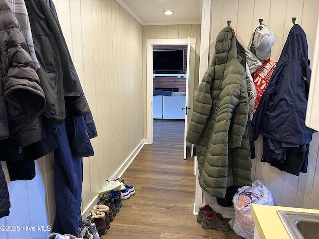 mudroom with a sink, crown molding, and wood finished floors