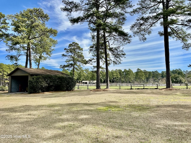 view of yard featuring fence, an outbuilding, and an outdoor structure