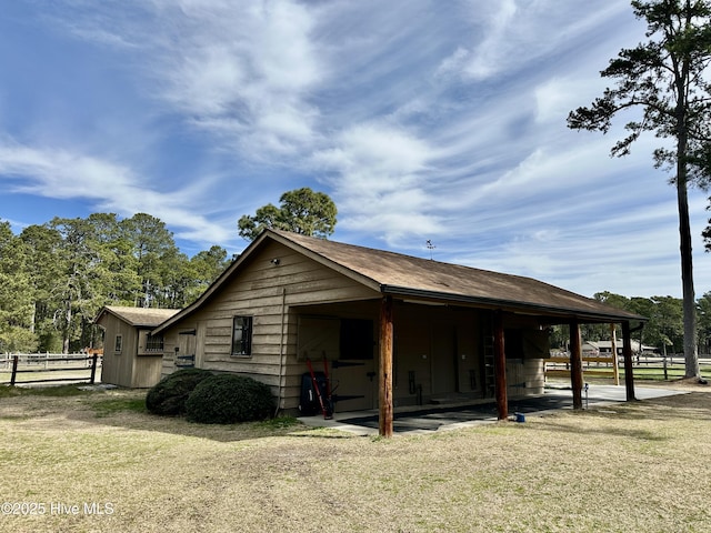 view of side of home featuring roof with shingles and fence