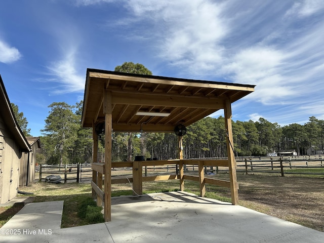 surrounding community with an exterior structure, an outdoor structure, and a view of trees