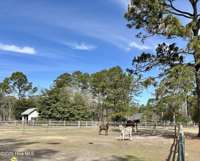 view of yard with an exterior structure, a rural view, and an outdoor structure