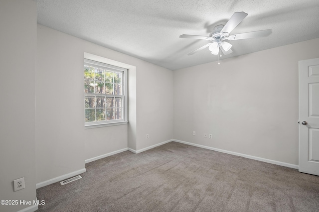 unfurnished room with a textured ceiling, visible vents, carpet flooring, and ceiling fan