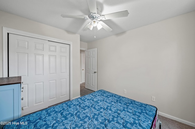 carpeted bedroom with a ceiling fan, a closet, and baseboards