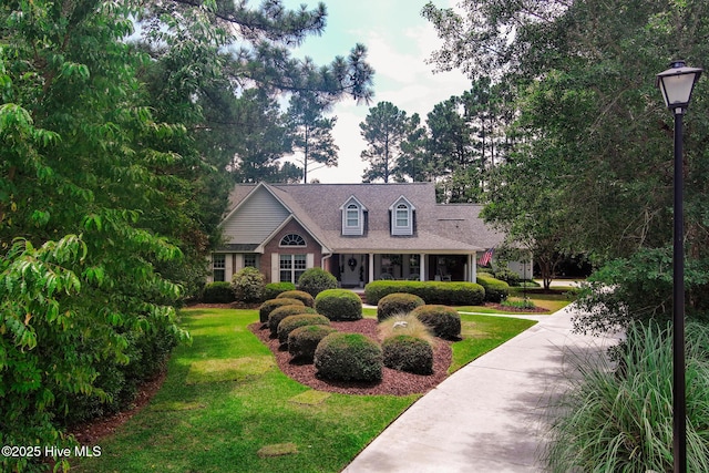 cape cod-style house with a front yard