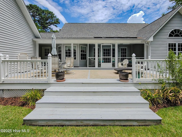 wooden terrace featuring a sunroom and a fire pit