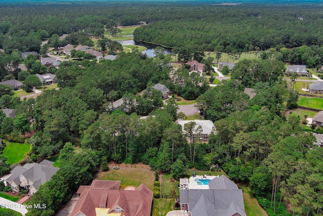 drone / aerial view featuring a water view, a wooded view, and a residential view