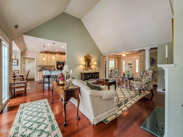 living room with recessed lighting, visible vents, wood finished floors, high vaulted ceiling, and ornate columns