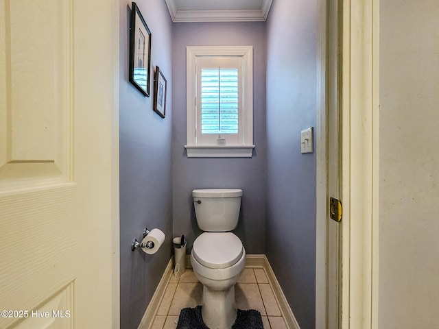 bathroom with toilet, baseboards, crown molding, and tile patterned floors