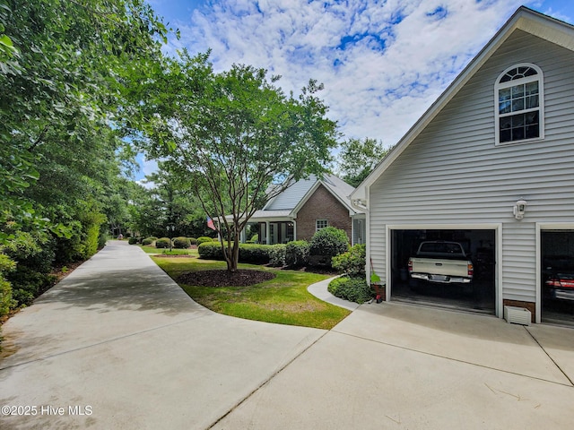 view of side of home featuring a garage and concrete driveway