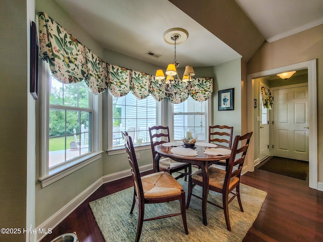 dining area featuring visible vents, vaulted ceiling, wood finished floors, a chandelier, and baseboards