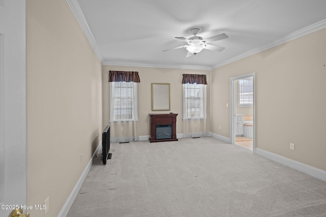 unfurnished living room featuring crown molding, baseboards, carpet flooring, and a healthy amount of sunlight