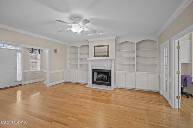 unfurnished living room featuring light wood-style flooring, baseboards, a fireplace with raised hearth, and crown molding