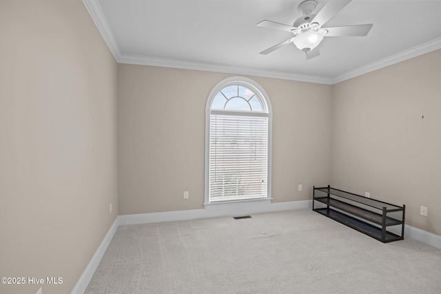 carpeted spare room featuring visible vents, crown molding, baseboards, and ceiling fan