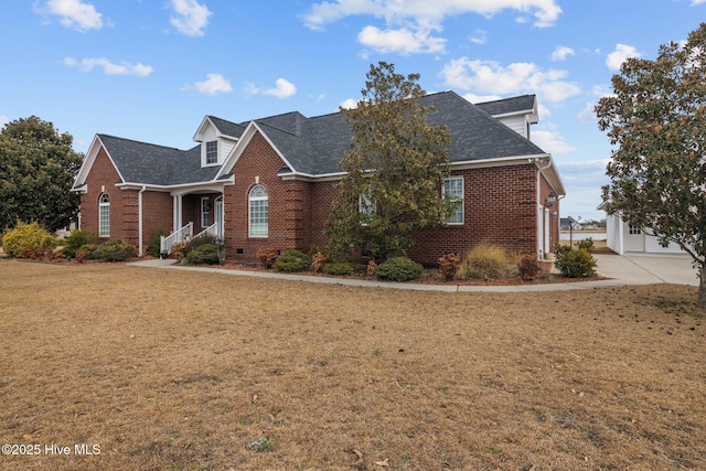 view of front facade featuring a shingled roof, brick siding, and a front lawn