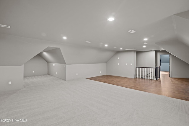 additional living space with recessed lighting, visible vents, vaulted ceiling, and carpet flooring