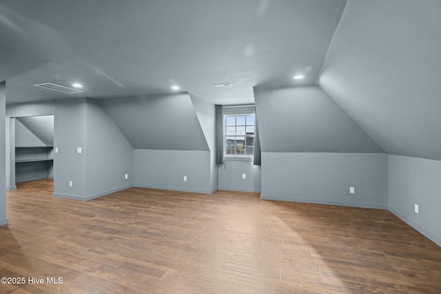 bonus room featuring lofted ceiling, recessed lighting, wood finished floors, visible vents, and baseboards