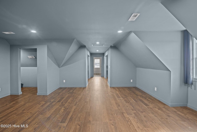 additional living space with vaulted ceiling, baseboards, wood finished floors, and recessed lighting