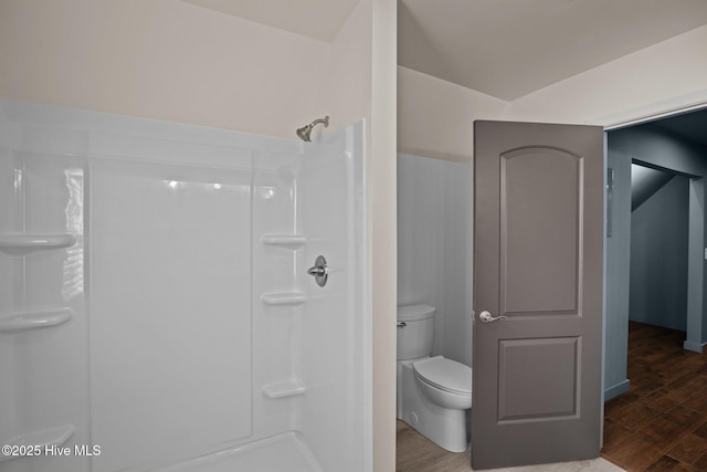 bathroom with a shower, wood finished floors, and toilet