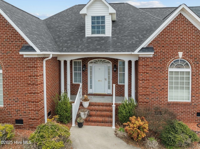 property entrance featuring roof with shingles, brick siding, and crawl space