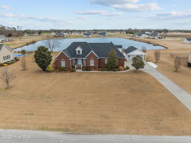 view of front facade featuring a water view, driveway, and brick siding