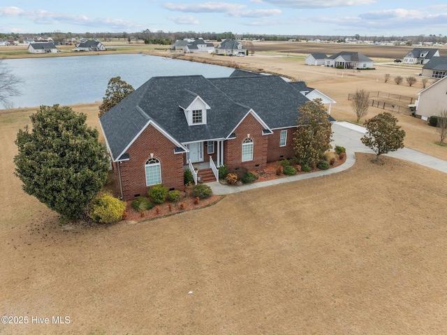 view of front of house with brick siding, a shingled roof, a water view, concrete driveway, and crawl space