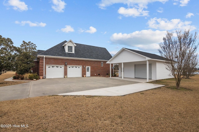 view of front facade featuring roof with shingles, brick siding, a front lawn, and a detached garage