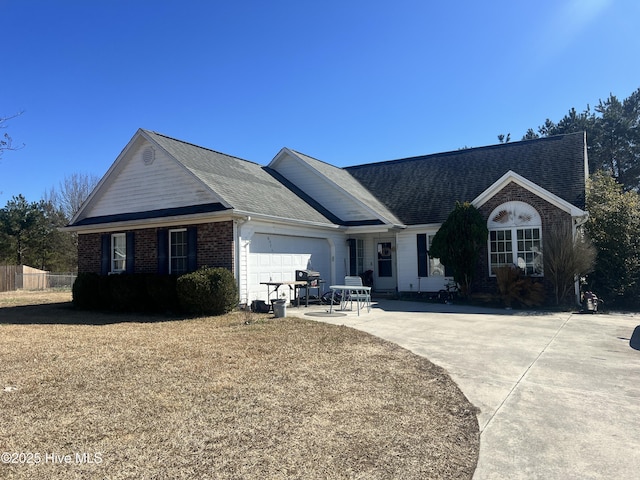 ranch-style home featuring an attached garage, driveway, a shingled roof, and brick siding