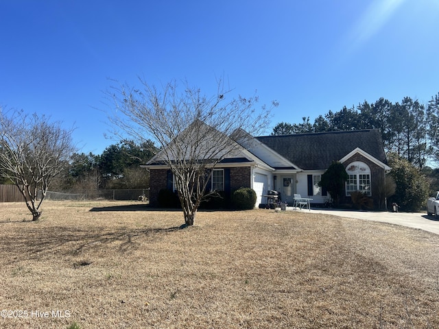 ranch-style house with an attached garage, brick siding, fence, concrete driveway, and a front lawn