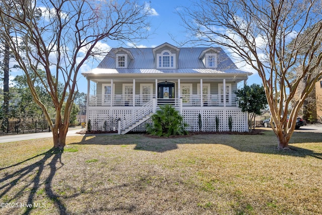 cape cod home with covered porch, metal roof, a front lawn, and stairs