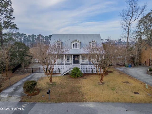 cape cod house featuring a porch, stairway, a front yard, and a gate