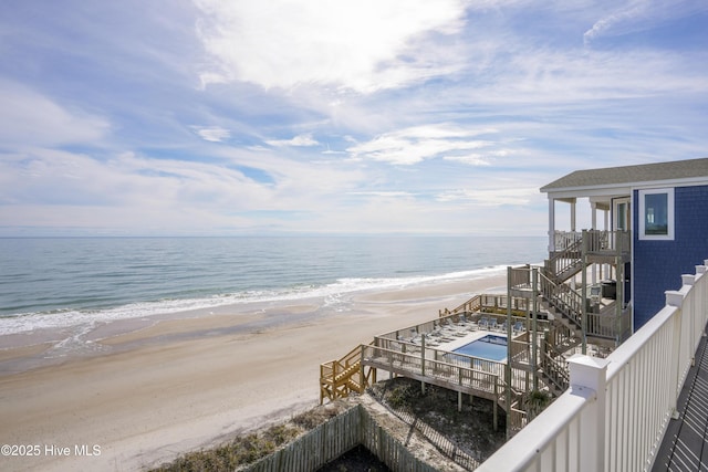 view of water feature with stairway and a beach view