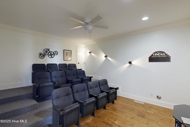 cinema with baseboards, ceiling fan, hardwood / wood-style flooring, and crown molding