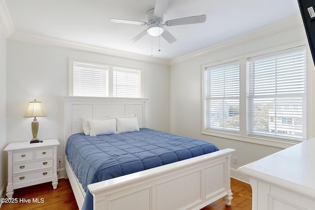 bedroom with ornamental molding, a ceiling fan, baseboards, and wood finished floors