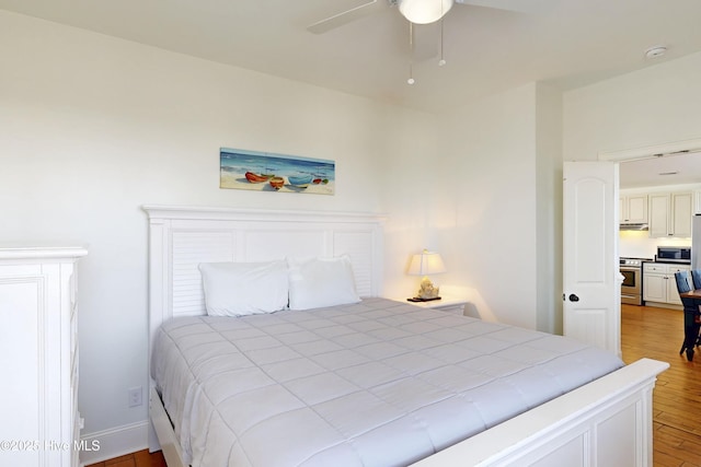 bedroom featuring light wood-style floors, ceiling fan, and baseboards