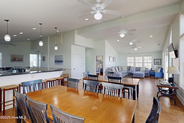 dining area with hardwood / wood-style flooring, high vaulted ceiling, and recessed lighting