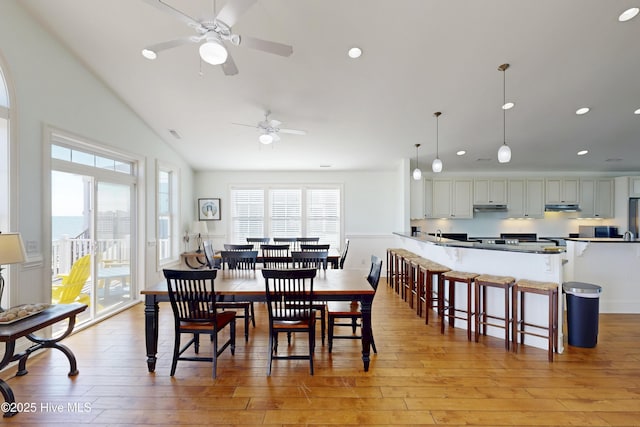 dining area with light wood-style flooring, vaulted ceiling, and recessed lighting