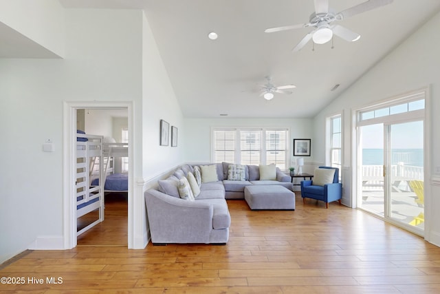 living room with ceiling fan, high vaulted ceiling, light wood finished floors, and baseboards