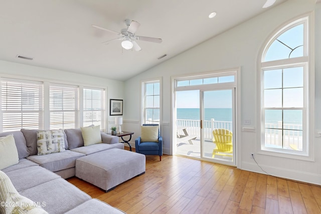 living room with light wood-type flooring, plenty of natural light, a ceiling fan, and lofted ceiling